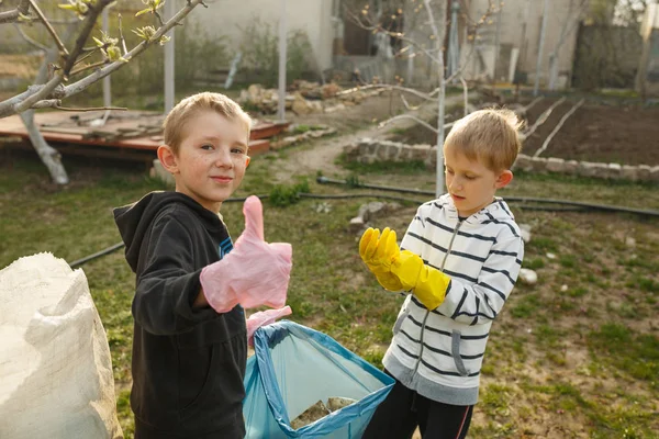 Zwei kleine Jungen im Park sammeln Plastikflaschen — Stockfoto