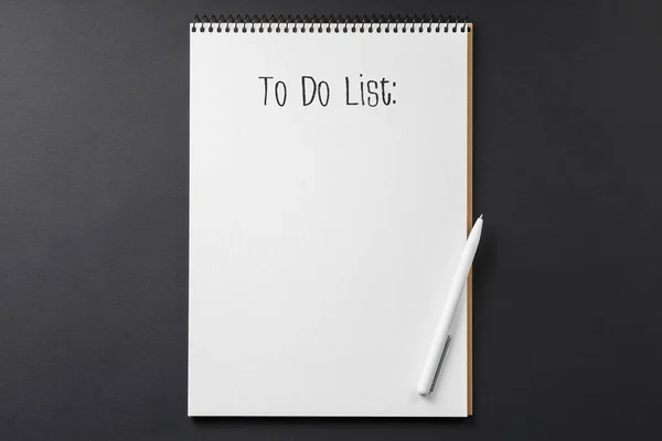 Сделать список тетрадей, белая ручка на чёрном фоне — стоковое фото