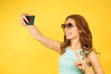 Kadın akıllı telefonda videoyla konuşuyor, selfie çekiyor.