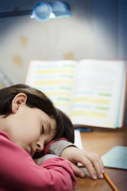 Küçük Asyalı kız okul ödevinde uyuyakalmış..