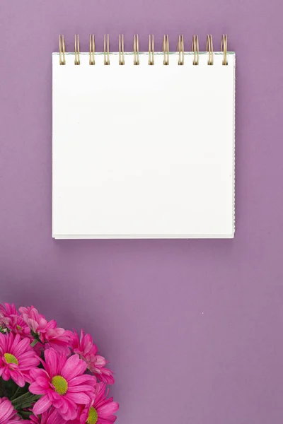 Top view of open notebook notepad with flowers.
