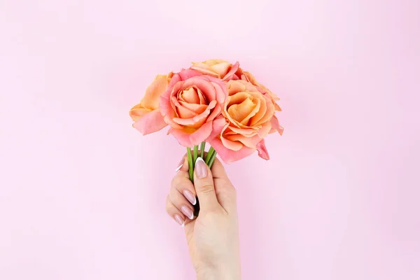 Strauß rosa Rosen in einer weiblichen Hand Nahaufnahme. — Stockfoto