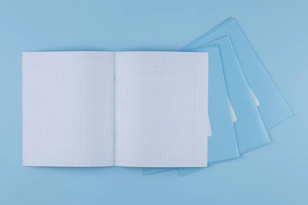 Cuaderno de la escuela en una vista superior de mesa azul — Foto de Stock