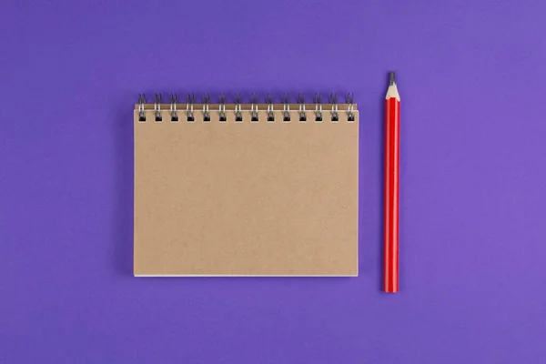 Taccuino scolastico con matita su sfondo viola — Foto Stock