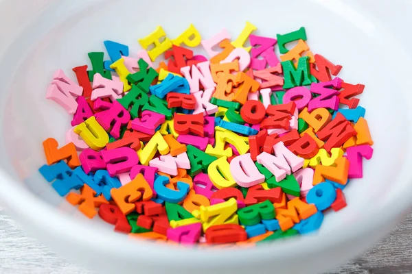 Letras de madera multicolor en un plato — Foto de Stock