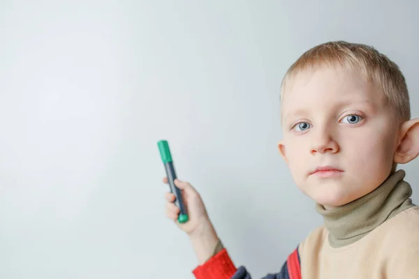Kind met stift in zijn hand punten op schoolbord — Stockfoto