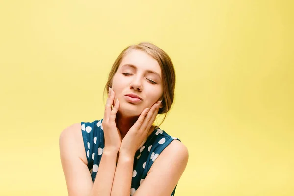 Menina bonita em um fundo amarelo faz um beijo — Fotografia de Stock