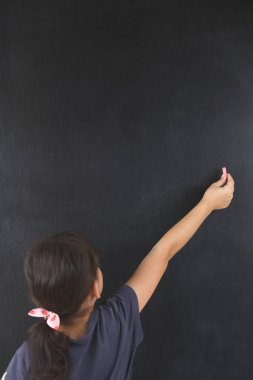 küçük kız bir tahta üzerinde tebeşir yazıyor