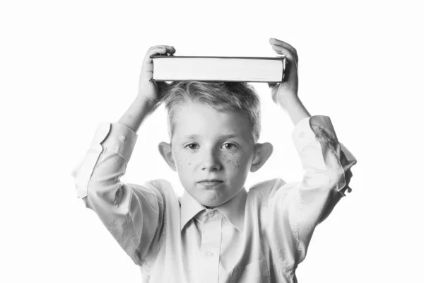 Kleine jongen houdt boek boven zijn hoofd — Stockfoto