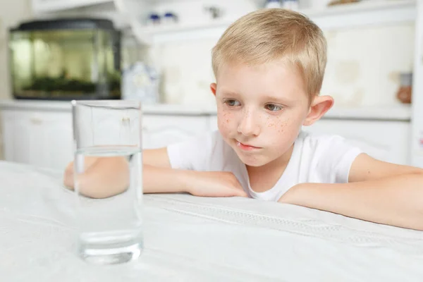 Niño en la cocina con un vaso de agua limpia — Foto de Stock