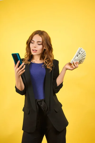 Жінка в куртці з телефоном і грошима — стокове фото