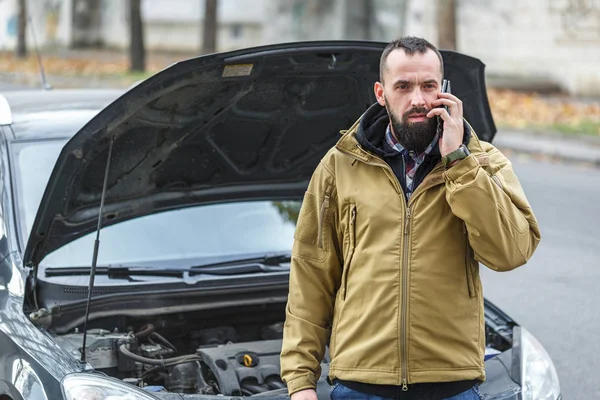 Guy is repairing car on the road