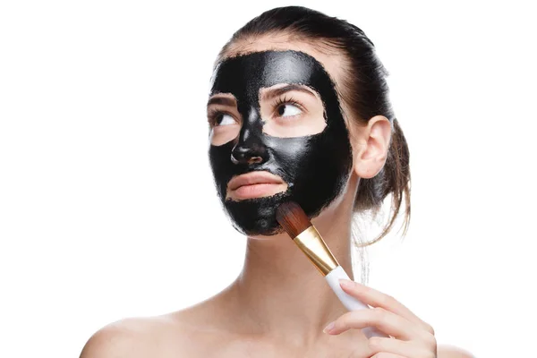 Meisje met zwart cosmetisch masker op gezicht — Stockfoto