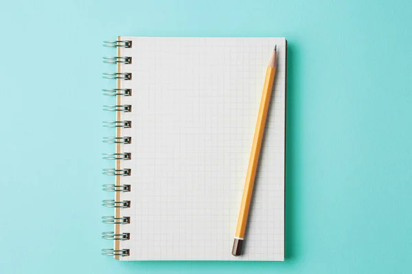 Escola notebook no fundo de cor ciano Visão superior — Fotografia de Stock