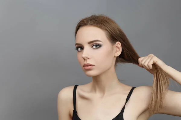 Mulher bonita segura o cabelo com as mãos . — Fotografia de Stock