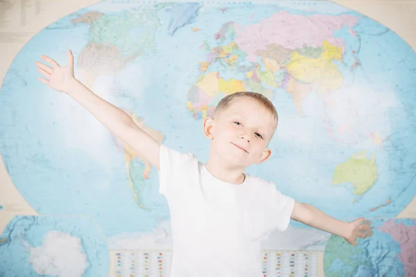 Niño pequeño en el fondo de un mapa del mundo —  Fotos de Stock