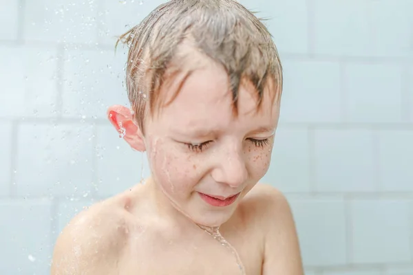 Kleiner Junge wäscht in der Dusche Shampoo auf seinem Gesicht — Stockfoto