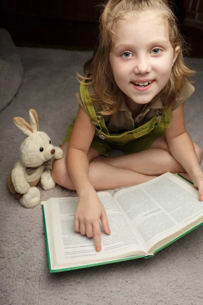 Piękna dziewczynka czytać książki dowcip ulubiona zabawka — Zdjęcie stockowe