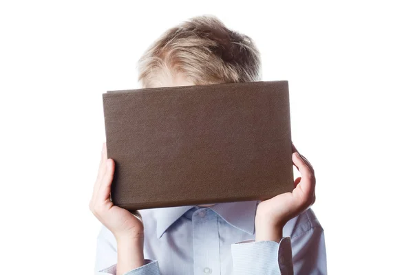 boy hides his face behind a book, portrait