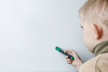 Elinde işaret olan bir çocuk bir görev üzerinde düşünür.