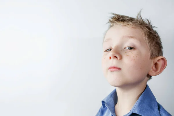 Jongen op witte achtergrond op zoek naar de camera — Stockfoto