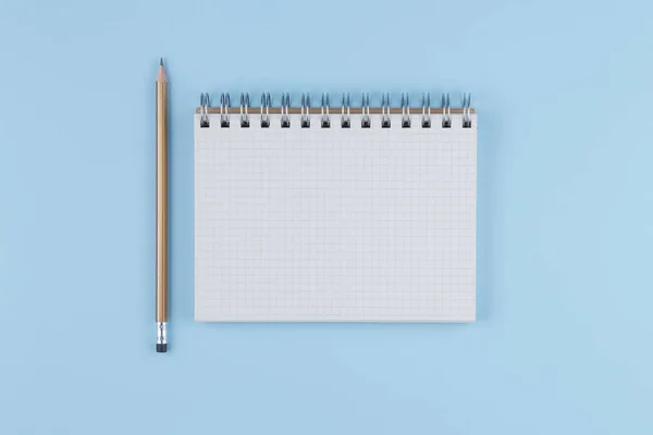 Cuaderno de la escuela con lápiz sobre tabla azul vista superior — Foto de Stock