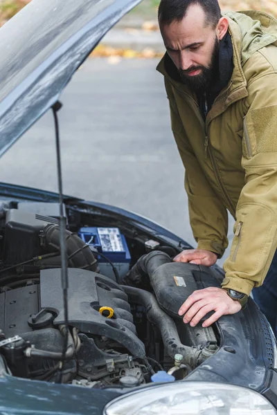 Guy is repairing car on the road