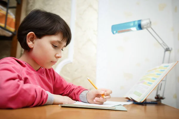 Азиатская маленькая школьница учит уроки дома . — стоковое фото