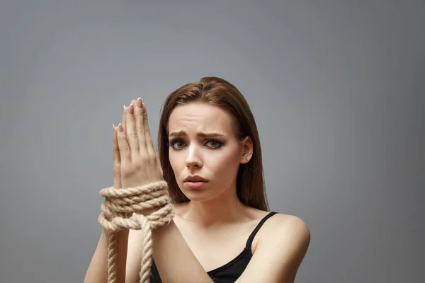 Jeune femme avec les mains liées avec la corde — Photo