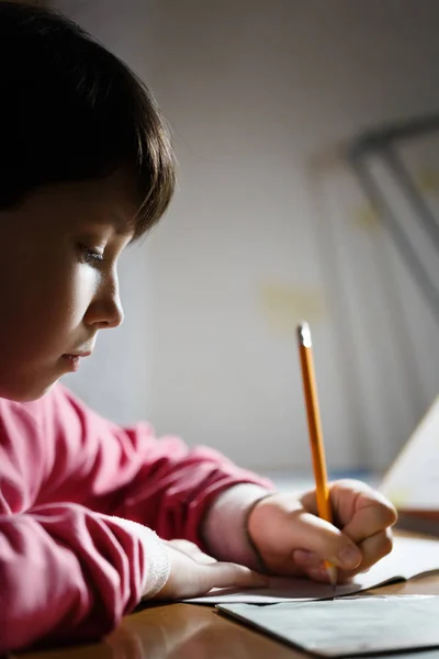 Азиатская школьница делает домашнее задание вечером . — стоковое фото