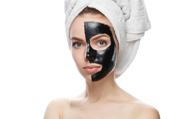 Meisje met zwart cosmetisch masker op gezicht en handdoek — Stockfoto