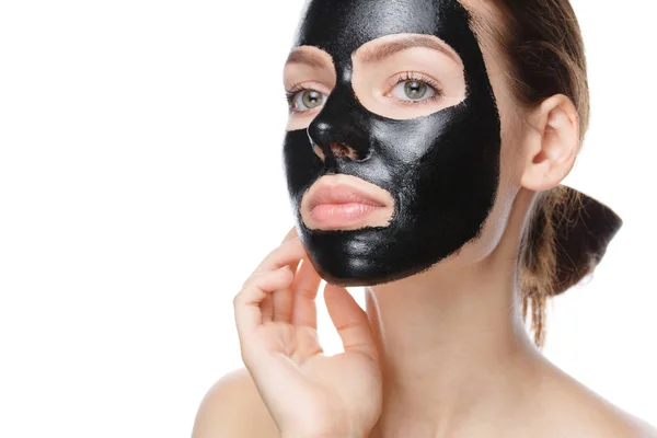 Meisje met zwart cosmetisch masker op gezicht poseren — Stockfoto