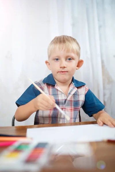 Boy draws colored pencils on paper — Stockfoto