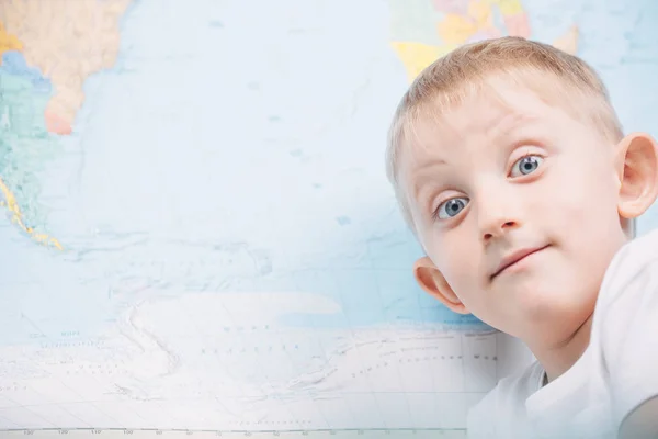 Μικρό αγόρι στο φόντο ενός παγκόσμιου χάρτη — Φωτογραφία Αρχείου