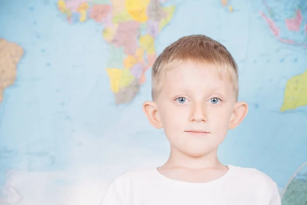 Niño pequeño en el fondo de un mapa del mundo —  Fotos de Stock