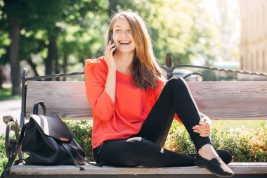 Sırt çantalı kız telefonda konuşuyor.