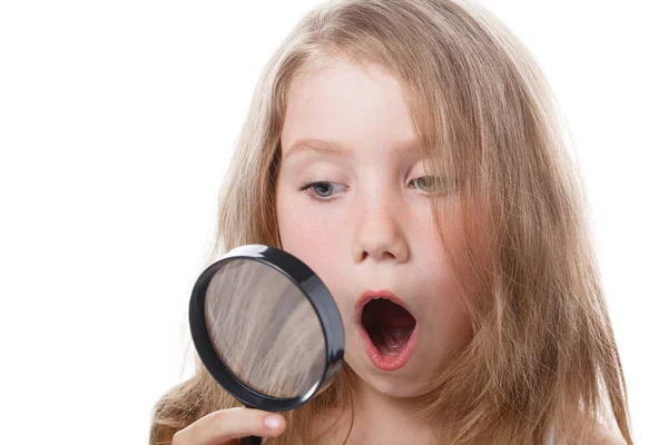 Little girl holds a magnifying glass in her hand — Stock Fotó