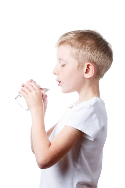A kisfiú tiszta vizet iszik üvegből. — Stock Fotó