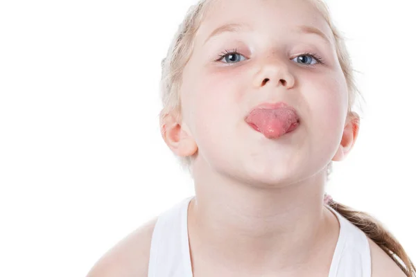 Pieni tyttö osoittaa kielen eristetty valkoinen — kuvapankkivalokuva