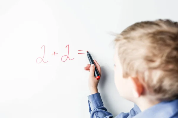 Child counts on the blackboard with a marker — Stock fotografie