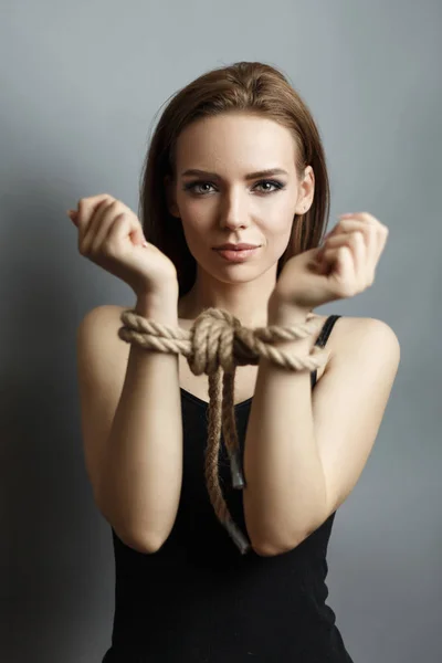 Excited young woman with tied hands with a rope