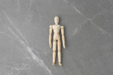 İzole edilmiş gri mermer arka planda tahta figür.