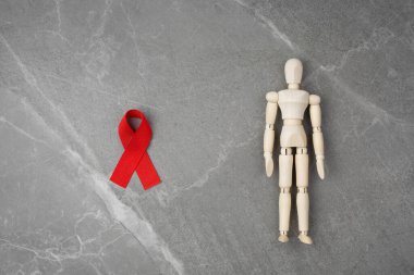 Tahta figür ve HIV kırmızı kurdelesi