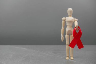 Tahta figür ve HIV kırmızı kurdelesi