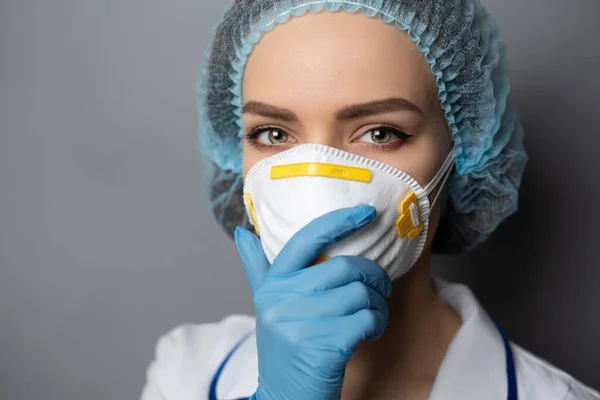 Enfermera en ropa médica sobre un fondo gris . — Foto de Stock