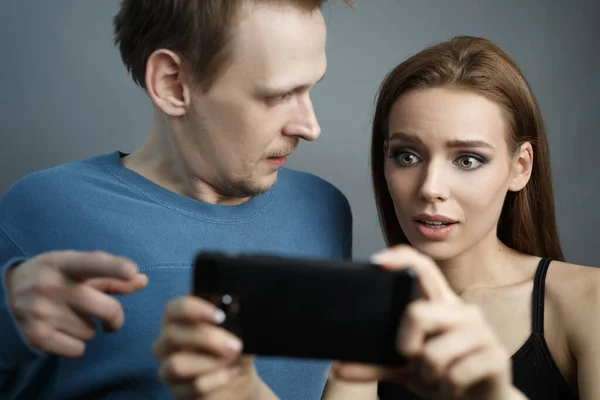 Chico con chica está mirando el teléfono inteligente —  Fotos de Stock