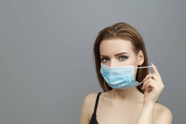Güzel kadın tıbbi maske takıyor.