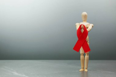 Tahta figür ve HIV kırmızı kurdelesi