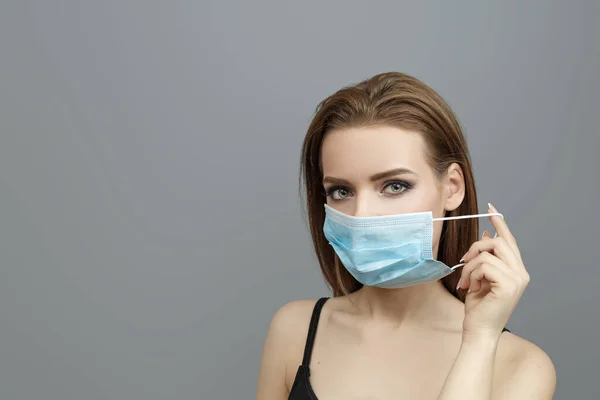 Güzel kadın tıbbi maske takıyor.
