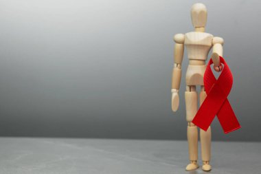 Tahta figür ve HIV kırmızı kurdelesi